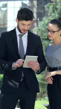 Kendine güvenen bir işadamı ve başarılı bir iş kadını canlı bir şehir vahasında bir tableti incelerken hareketli bir tartışmaya girişirler. Şık profesyonel kıyafetleri ve anlamlı yüzleri, bir arka planda belirlenen hırs ve takım çalışmasına ışık saçıyor.