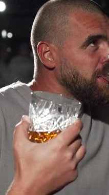 İki yakışıklı adam viski barında keyifli bir anı paylaşıyor. Yoğun bir futbol maçından büyülenirken kadehlerini neşeyle kaldırıyorlar. Titreşimli atmosfer heyecanla uğulduyor, kahkahalarla dolu, viskinin zengin kokusu