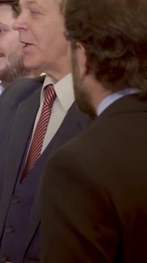 Çeşitli iş adamları, parlak bir ofiste canlı bir tartışmaya tutkulu bir şekilde girişiyor. Takım elbiseli, kıdemli, gri saçlı bir adam, kapaklı çizelge üzerinde fikirler sunuyor. Bu enerjik sahne işbirliğinin özünü yakalıyor.