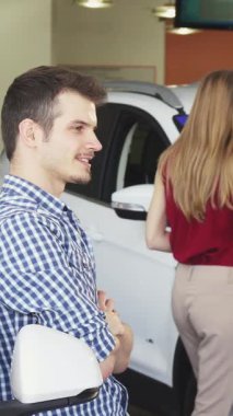 Işıldayan genç bir adam kendine güvenen yeni arabasının yanında duruyor, elinde muzaffer bir sırıtışla anahtarları tutuyor. Modern bir bayiliğin bu canlı sahnesi yeni sahipliğin heyecanını ve heyecan verici yolculuklara çıkmanın hazzını yayıyor.