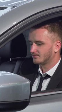 Şık sakallı neşeli bir işadamı, çarpıcı yeni aracının parlak araba anahtarlarını elinde tutarken gururla ışıldıyor. Bu dinamik sahne heyecan ve başarı yayar, sahipliğin heyecanını ve devam etmenin hazzını kapsar.