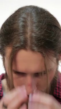 Moda düşkünü genç sakallı bir hippi uzun saçlarını, özgüvenini ve modern yeteneğini el değmemiş beyaz arka planına göre ayarlıyor. Bu çarpıcı portre, onun erkeksi cazibesini ve modaya uygun kıyafetlerini yansıtıyor.