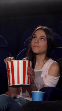 Çekici bir genç adam, sıcak bir sinemada iki güzel kadını kucaklıyor, kahkahaları bir film galasının heyecanı arasında yankılanıyor. Canlı atmosfer neşe, dostluk ve patlamış mısırın enfes aroması ile dolu. Mükemmel bir film yaratıyor.