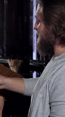 Hareketli bir barda, neşeli bir arkadaş üçlüsü bir kadın ve iki menklin buzlu bira bardakları, neşeli Oktoberfest ruhunun keyfini çıkarıyorlar. Bar ışıklarının sıcacık, davetkar parıltısı kahkahalarını ve arkadaşlıklarını vurguluyor.