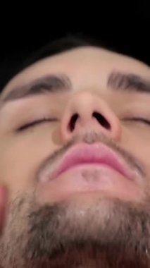 Yetenekli bir berber, yakışıklı bir müşteriye, modern bir berber dükkanının şık atmosferine sarılı bir yüz masajı yapar. Klasik dekor ve yumuşak ışıklandırma, kendine dikkat etmek ve rahatlamak için mükemmel, sakin bir atmosfer yaratır.