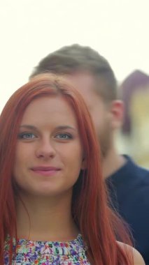 Sakallı bir adam, sevgilisiyle romantik bir öpücük için eğilir. Etrafı, altın akşam ışığında yıkanmış eski bir kasabanın büyüleyici cazibesiyle çevrilidir. Neşeli ifadeleri ve günlük kıyafetleri sevgi ve bağlılık yayar, mükemmel bir görüntü yakalar.