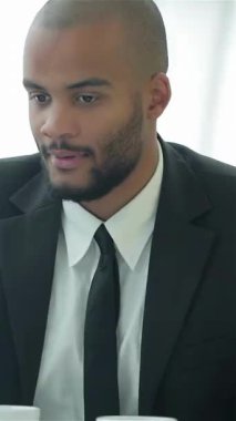 In a sleek, modern office, two confident businessmen engage in a dynamic discussion, exchanging valuable insights over important documents. Their animated expressions and bright surroundings create an atmosphere brimming with collaboration