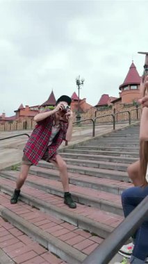 Three vibrant young friends burst with laughter as they pose playfully on colorful outdoor steps, capturing the essence of carefree summer fun. The scene is alive with bright smiles and dynamic gestures, radiating the joy of friendship and adventure