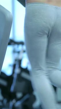 Two fit and energetic girls are sprinting on sleek treadmills in a bright, modern gym, radiating dedication and vitality. Clad in stylish sportswear, they embody strength and determination, inspiring others on their fitness journey