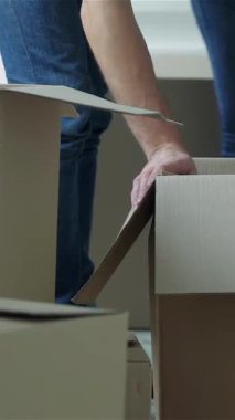A loving couple, radiating joy, eagerly unpacks cardboard boxes in their bright, modern apartment. Their shared smiles and warm embraces fill the space with excitement, symbolizing new beginnings and the adventure of creating a home together