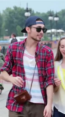 Three stylish young friends stroll along a lively street, exchanging laughter and bright smiles under the golden sun. Their vibrant outfits and carefree demeanor radiate the essence of friendship, summer adventures, and unforgettable moments