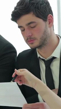 Üç keskin zekalı işadamı yüksek bahisli bir toplantıda hayati önem taşıyan belgeleri yoğun bir şekilde inceleyerek güven ve hırs yayıyorlar. Stratejiler üzerinde işbirliği yaparlarken parlak, modern ofis ayarları enerji ile uğulduyor.