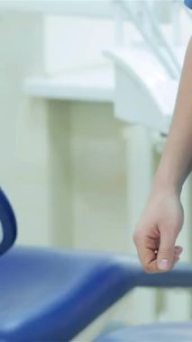 Neşeli bir hasta gösterişli, modern bir diş hekiminde dişçiyle coşkuyla el sıkışıyor. Güven ve profesyonellik yayıyor. Bu davet sahnesi, gelişmiş diş ekipmanlarını ve rahat bir ortam yaratmak için konforlu bir diş sandalyesini ön plana çıkarıyor.