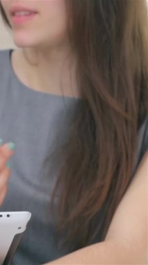 Yakın plan çekimde genç, çekici bir iş kadını ve işadamının dinamik elleri, zarif bir tablet üzerindeki verileri tartışmakla derinden meşgul. Odaklanmış ifadeleri modern ofislerin parlak atmosferiyle birleşince ilham verici bir şey yaratıyor.