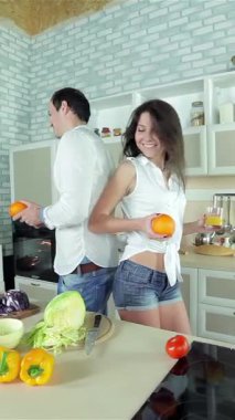 Neşeli, güneşli bir mutfakta, neşeli bir çift, lezzetli bir yemek hazırlarken, sırt sırta, neşe içinde portakalları tutuyor. Renkli sebzelerden oluşan bir gökkuşağı ve taze malzemelerin baştan çıkarıcı aromasıyla çevrili, ışıl ışıl gülümsemeleri ve...