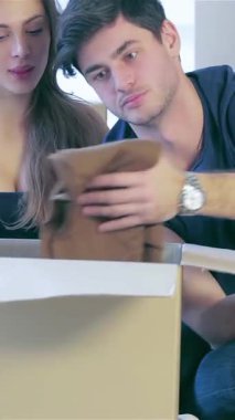 Heyecan ve sevgi dolu genç bir çift, açık karton kutularla çevrili yeni dairelerinin zemininde oturuyor. Parlak gülümsemeleri ve neşeli bakışları yeni başlangıçların heyecanını yansıtıyor. Hazineleri açmaya can atıyorlar.