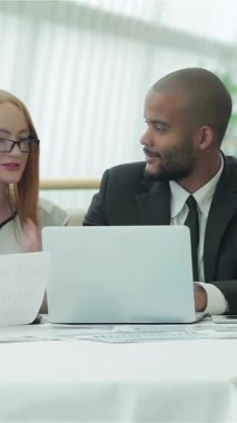 Sivri iş kıyafetleri içinde dört genç profesyonelden oluşan canlı bir grup, parlak ve modern bir ofiste buharlı aromatik kahve fincanları üzerine hevesle fikir alışverişinde bulunuyor. Animasyon jestleri ve sıcak gülümsemeleri davetkar bir atmosfer yaratıyor.