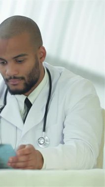 El değmemiş beyaz önlüklü ciddi bir doktor bir hastayla göğüs röntgeni bulgularını dikkatlice tartışıyor, sağlığa ve sağlığa olan bağlılığını gösteriyor. Parlak, modern klinikte profesyonellik yayılıyor.