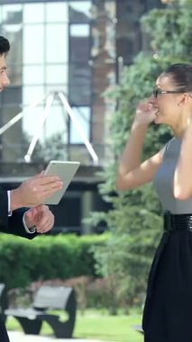 Dinamik bir işadamı ve enerjik bir iş kadını, şık bir şehir ofis ortamı tarafından çerçevelenmiş olan açık havada başarılarını coşkuyla kutluyorlar. Animasyon jestleri, parlak gülümsemeleri ve şık kıyafetleri pozitifliği ve zaferi simgeliyor.