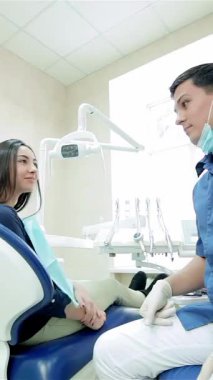 In a bright and modern dental clinic, a young, confident dentist and a smiling female patient share a joyful thumbs up, radiating positivity and trust. This vibrant scene captures the essence of friendly dental care, where health and happiness
