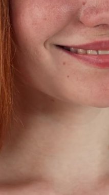 This cropped studio shot features a radiant red-haired woman whose joyful expression lights up the scene, showcasing her brilliant smile against a lively green chromakey backdrop. Her flawless, pearly white teeth and glowing complexion embody the
