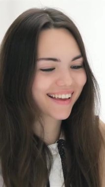 A cheerful young woman with flowing dark hair radiates positivity as she actively participates in a vibrant business discussion with professional men in sharp suits. The modern office buzzes with energy, showcasing collaboration and creativity as