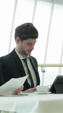 A dynamic group of four young professionals, dressed in sleek formal attire, actively engage in a vibrant meeting around a polished conference table. The bright, modern office setting radiates positive energy as they exchange innovative ideas and