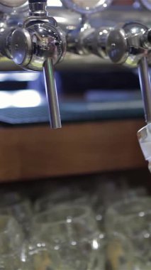 A skilled bartender pours a golden lager into a frosty mug, creating a perfect creamy head that bubbles with excitement. This vibrant scene captures the lively atmosphere of a bustling pub, inviting patrons to indulge in a refreshing drink amidst the