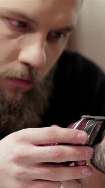 Şık bir berber dükkanında, kendini işine adamış bir berber müşterisinin sakalını ustalıkla yontuyor, titiz bir hassasiyet ve sanatçılık sergiliyor. Samimi ortam modern erkeksiliği ve kendine bakımı yansıtıyor. Odaklanmış berberle odaklı berber arasındaki ilişkiyi vurguluyor.