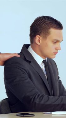 In a sleek, contemporary office, a young male businessman diligently types on his laptop, while a supportive colleague gently places a hand on his shoulder, embodying teamwork. This engaging scene highlights the synergy of professional collaboration