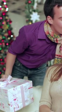 Yürek ısıtan bir Noel sahnesinde, rahat süveter giyen genç bir çift sevgi ve neşe saçıyor. Göz kamaştırıcı ışıklar ve güzel dekore edilmiş bir ağaçla süslenmiş büyüleyici oda onları büyülü bir tatil atmosferiyle kaplıyor.