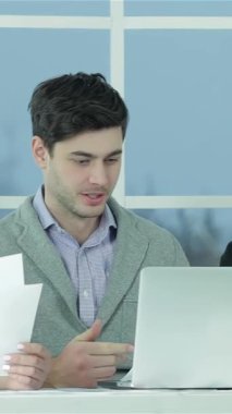 Genç profesyonellerden oluşan dinamik bir üçlü, bir erkek ve iki kadın, belgeler ve parlak bir dizüstü bilgisayarı incelerken tutkuyla ortak bir tartışmaya giriştiler. Kararlı ifadeleri ve enerjik enerjileri yaratıcılık ve üretkenlik yayıyor.