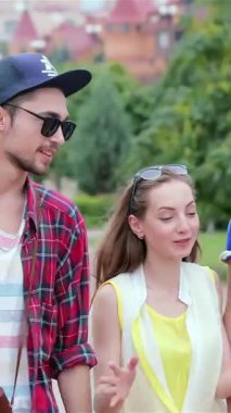 Üç şık genç arkadaş canlı bir caddede yürüyor, gülüyor ve altın güneşin altında hikayelerini paylaşıyorlar. Kaygısız gülümsemeleri ve şakacı jestleri arkadaşlığın özünü yansıtıyor, bu güzel birlikteliğin neşesini yakalıyor.