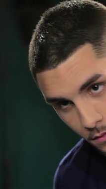 Titiz bir sakalı ve keskin bir saç kesimi olan şık bir genç adam klasik bir berber aynasında yansımasını inceliyor. Berberin sakalını ustalıkla şekillendirmesi modern sanatın sanatını ön plana çıkarırken, ortam klasik bir zarafet yayıyor.