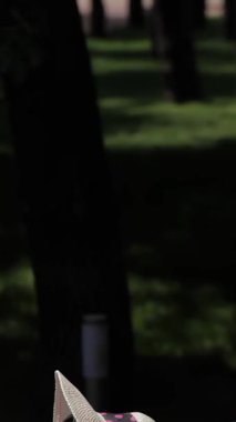 İki güzel beyaz kadın, biri esmer, diğeri parlak kızıl saçlı, parlak bir havuzun yanında canlı pembe şezlonglarda güneşleniyorlar. Şık bikiniler ve geniş kenarlı şapkalarla süslenmiş, rahatlama ve neşe saçıyorlar.