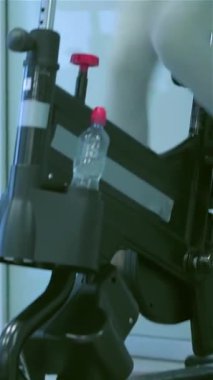 Parlak ışıklar ve motivasyon posterleriyle dolu canlı bir spor salonunda, iki genç bayan spor bisikletleri üzerinde enerjik bir şekilde pedal çeviriyor, neşe ve kararlılık saçıyor. Neşeli gülümsemeleri ve dinamik hareketleri heyecan verici bir atmosfer yaratıyor.