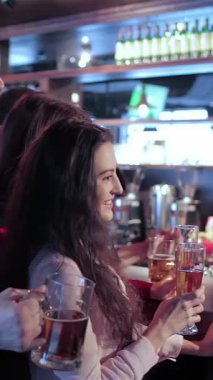 Dört eski arkadaş, iki erkek ve bir kadın yukarıdaki ışıkların sıcacık parıltısıyla aydınlanan hareketli bir barda kadehlerini sevinçle kaldırırken canlı bir sahne beliriyor. Bulaşıcı gülümsemeleri ve tezahüratları heyecanla yankılanıyor, en sevdiklerini kutluyorlar.