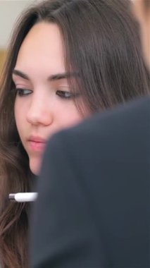 Yakın plan çekimde genç bir çift iş danışmanlığına dalmış, kararlılık ve takım çalışması yayıyor. Yumuşak ışıklandırma, bir dizüstü bilgisayardaki detayları analiz ederken odaklanmış ifadelerini vurguluyor, hırs ve profesyonelliği somutlaştırıyor.