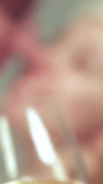 Sıcak süveter ve eşarplara sarılı neşeli bir çift, güzel dekore edilmiş bir Noel odasında ışıltılı bardaklar kaldırırken şefkatli bir öpücük paylaşıyor. Parıldayan ışıkların sıcacık parıltısı ve şenlikli süsler büyüleyici bir aşk atmosferi yaratır.