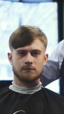 Saçını ustalıkla şekillendiren yetenekli bir berber gibi, bakımlı sakallı şık bir genç adam klasik bir berber koltuğuna güvenle oturur. Zengin yeşil duvarlar ve klasik dekorlar berberliğin sanatını gösteren davetkar bir atmosfer yaratıyor.