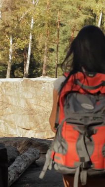 Sırt çantaları omuzlarının üzerinden sarkan cesur bir çift yürüyüşçü, aşağıdaki yemyeşil orman tarafından büyülenmiş, çarpıcı bir uçurumun kenarında durakladı. İnce esmer kadın, erkek arkadaşıyla şefkatli bir öpücük için eğilir ve güzel bir kadını kapsüle dönüştürür.