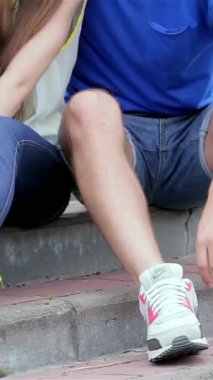 Three cheerful friends, basking in the warm sunlight, gather on the steps to snap a lively selfie, their smiles radiating pure joy. The scene is filled with laughter and a carefree summer spirit, showcasing their close bond and youthful energy