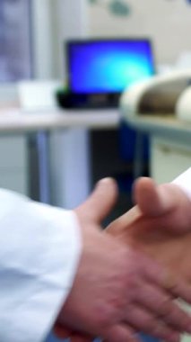 A dedicated Caucasian male scientist in a pristine white lab coat stretches his hands after a firm handshake, signaling readiness for a day of groundbreaking research. The close-up of his hands, gently massaging each other, conveys anticipation and