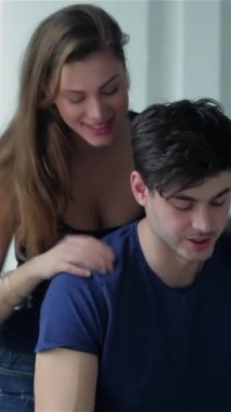 In a sunlit, empty apartment, a cheerful couple shares a warm embrace, surrounded by scattered moving boxes that hint at their new adventure. Their radiant smiles and intimate connection reflect the excitement of unpacking their lives together