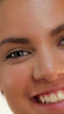 A captivating close-up of a radiant young woman with curly hair and a dazzling, toothy smile, radiating pure joy and positivity. Her luminous skin and sparkling eyes create an inviting ambiance, showcasing beauty, confidence, and a vibrant