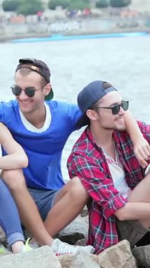 Three young friends bask in the warmth of a sunny day by the river, sharing laughter and carefree moments. Their vibrant smiles and playful poses embody the spirit of friendship, creating unforgettable memories in a picturesque outdoor setting