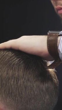 A close-up shot reveals a professional barber meticulously spraying water onto a clients hair, enhancing the styling process in a vintage barbershop. The atmosphere exudes elegance and craftsmanship, highlighting the barbers dedication and the