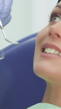 In a bright dental clinic, a dedicated dentist, clad in blue gloves, meticulously inspects the pearly whites of a lovely young woman. This intimate moment showcases the precision of dental care, with gleaming instruments reflecting the commitment to