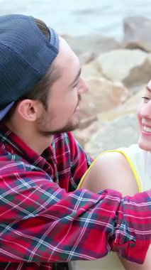 A delightful trio of young friends playfully connect by the shimmering water, their foreheads gently touching as laughter fills the air. This vibrant scene radiates warmth and the carefree spirit of summer, celebrating friendship and joyful moments