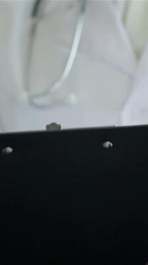 In a bright, modern clinic, a dedicated doctor in a crisp white coat writes a prescription, fully engaged with a patient. This intimate moment highlights the essence of compassionate healthcare, showcasing professionalism and a supportive atmosphere